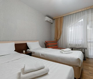 Номер стандарт трёхместный с двумя раздельными кроватями и балконом. Гостевой дом Ева. 